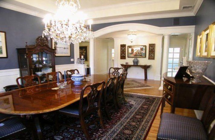 A dining room with a long table and chairs and a chandelier