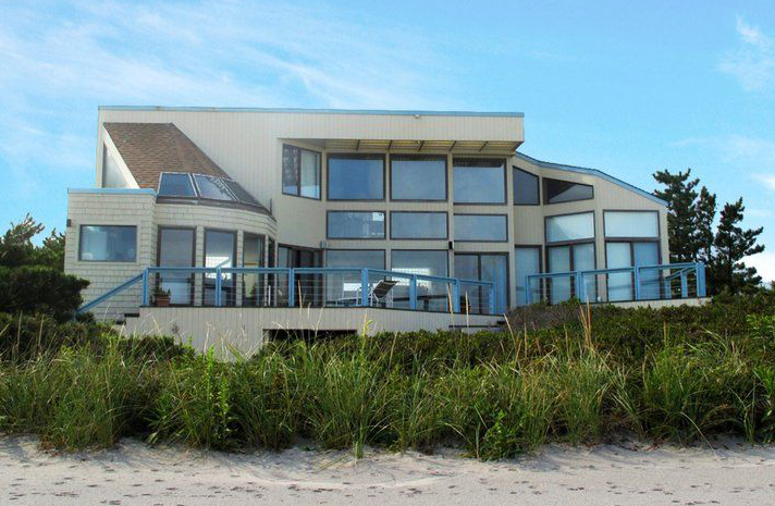 A large house with lots of windows sits on top of a hill