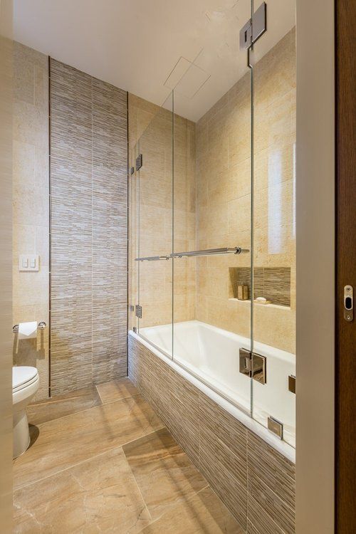 A bathroom with a bathtub , toilet and shower.