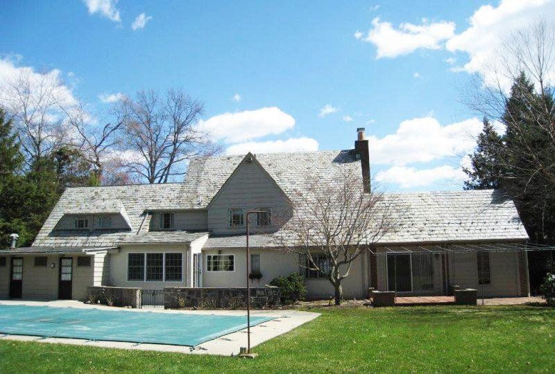 A large house with a swimming pool in front of it