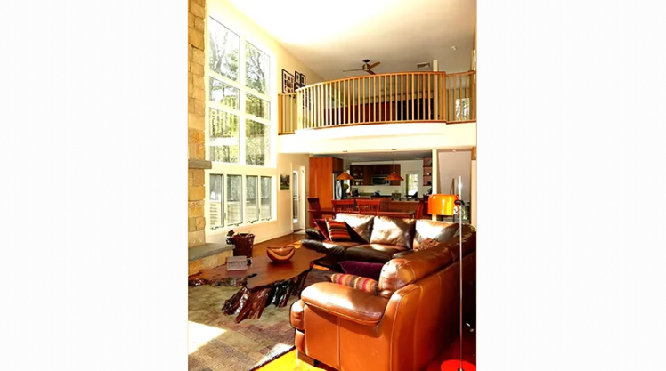 A living room with a couch and chairs and a balcony