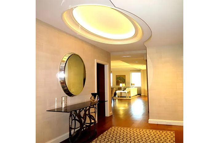 A hallway with a table and a mirror on the wall