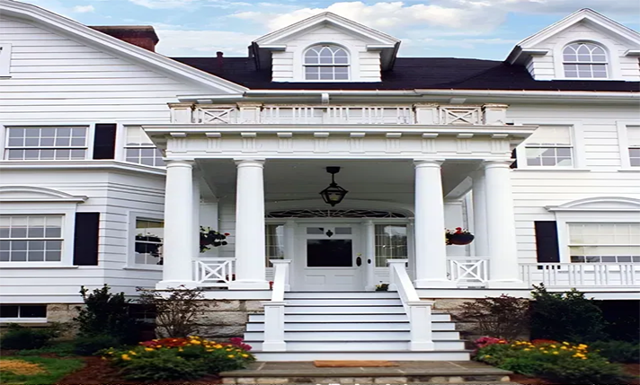 A large white house with a porch and stairs