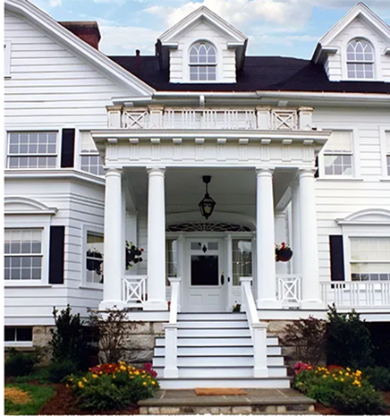 A large white house with a porch and stairs