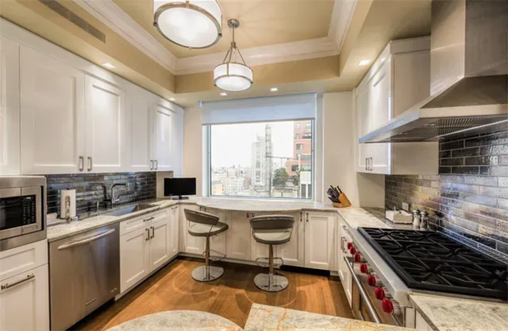 A kitchen with white cabinets and stainless steel appliances