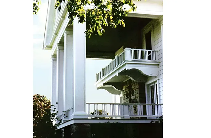 A large white house with a balcony and columns