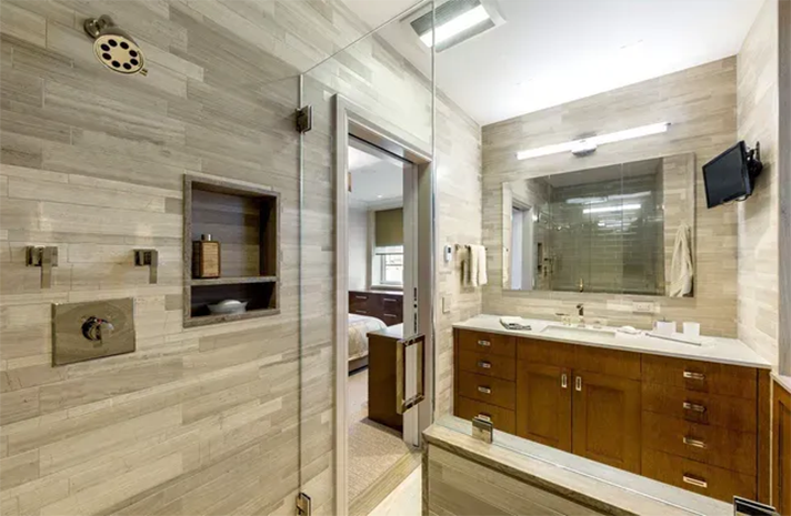 A bathroom with a walk in shower , sink and mirror.
