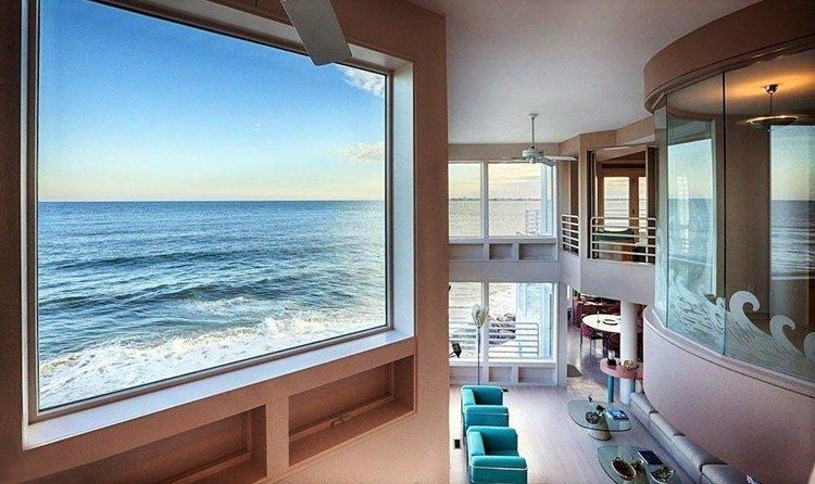 A living room with a large window overlooking the ocean