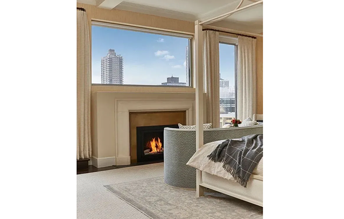 A bedroom with a fireplace and a canopy bed.