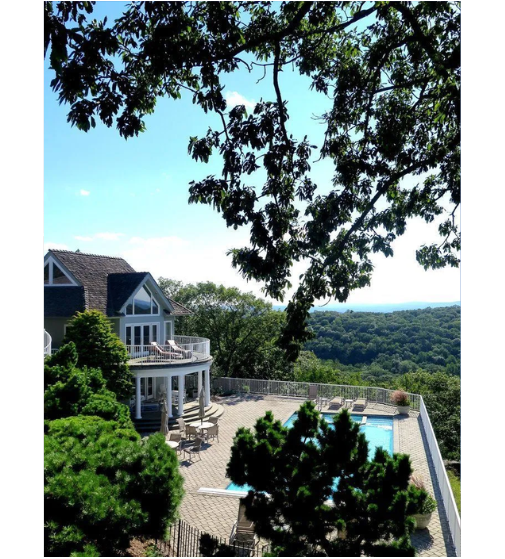 A large house with a large swimming pool in front of it