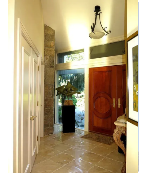 A hallway with a red door and a picture on the wall