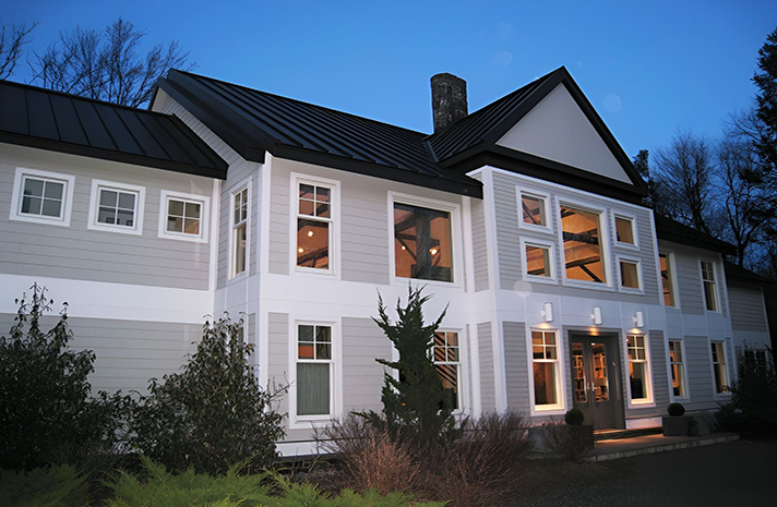 A large house with lots of windows and a black roof