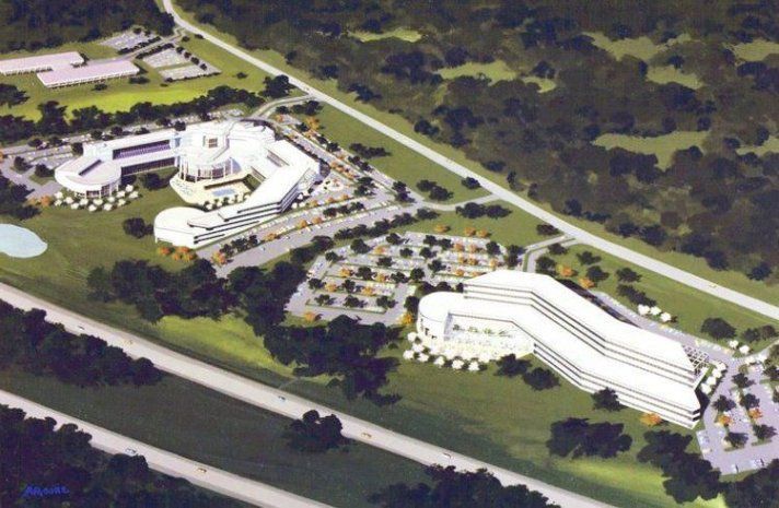 An aerial view of a large white building surrounded by trees