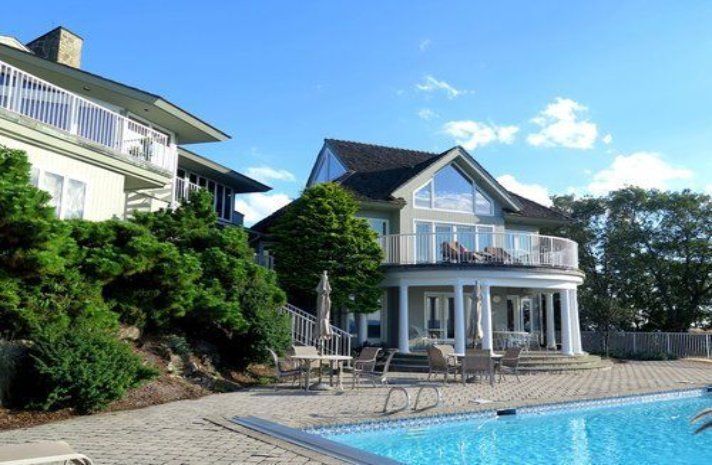 A large house with a swimming pool in front of it