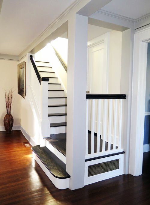 A white staircase with black steps and a white railing