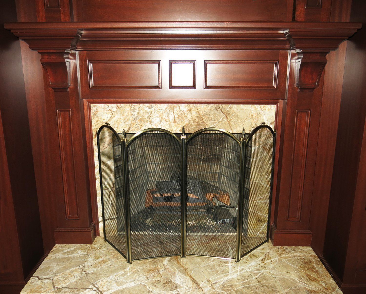 A fireplace with a screen and a wooden mantle