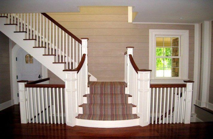 A staircase with a plaid carpet and white railings