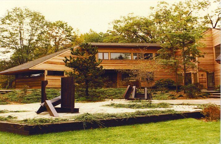 A large wooden house with a sculpture in front of it