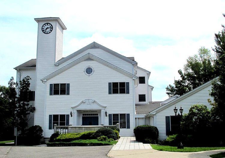 A large white house with a clock on top of it