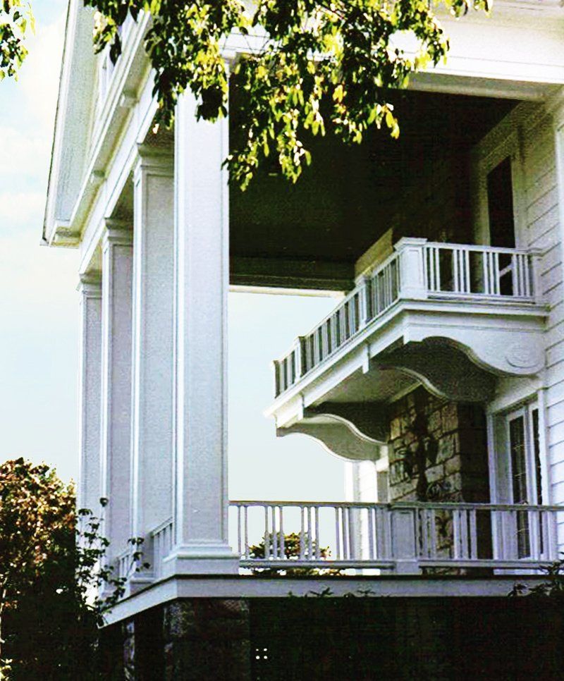 A large white house with a balcony and columns