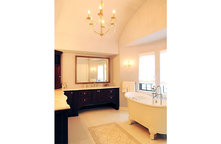 A bathroom with two sinks and a tub with a chandelier hanging from the ceiling