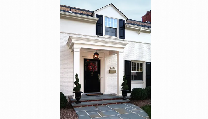 A white house with a black door and black shutters