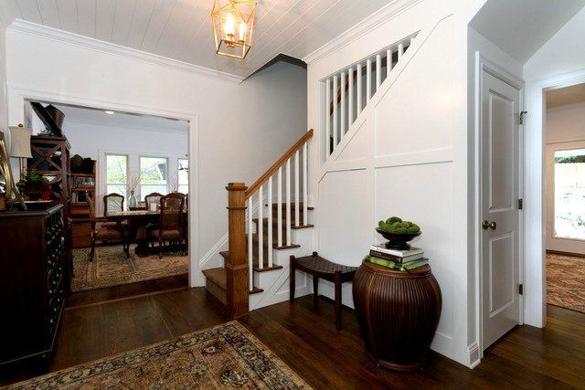 A hallway with stairs leading up to the second floor of a house.