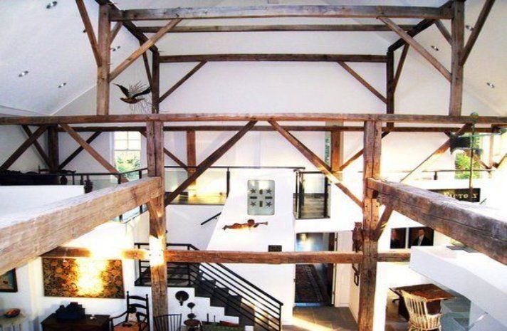 A large room with wooden beams and a staircase
