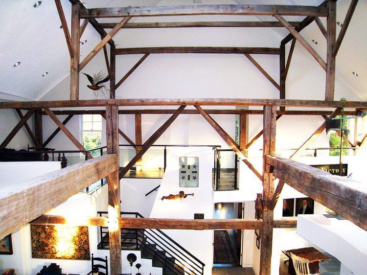 A large room with wooden beams and white walls