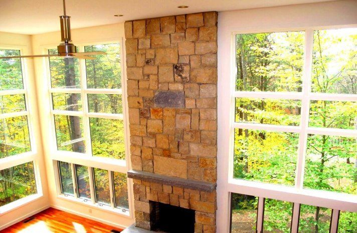 A living room with a fireplace and lots of windows