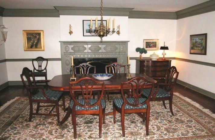 A dining room with a table and chairs and a fireplace