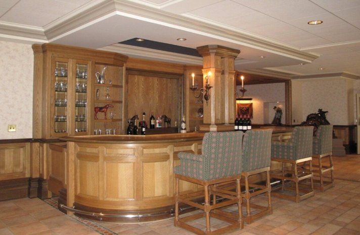 A large wooden bar in a room with chairs