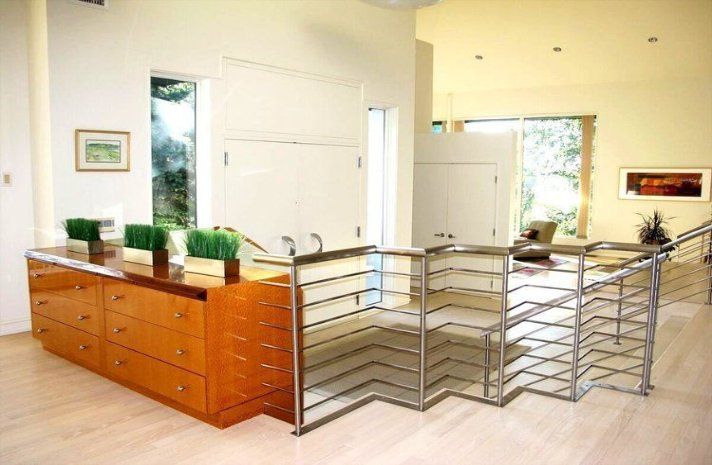 A living room with a staircase and a dresser