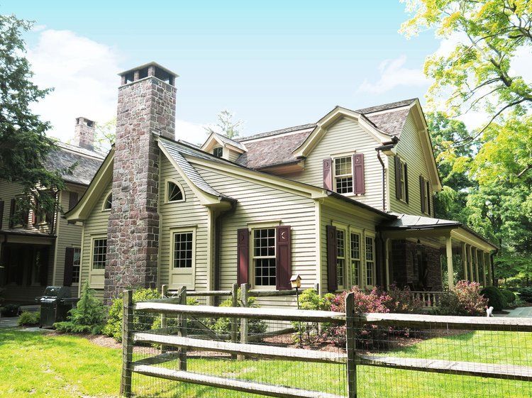 A large white house with a wooden fence in front of it.