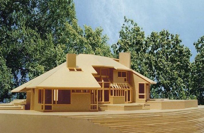 A model of a house with trees in the background