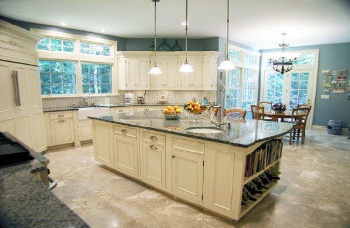 A kitchen with white cabinets and a large island in the middle.