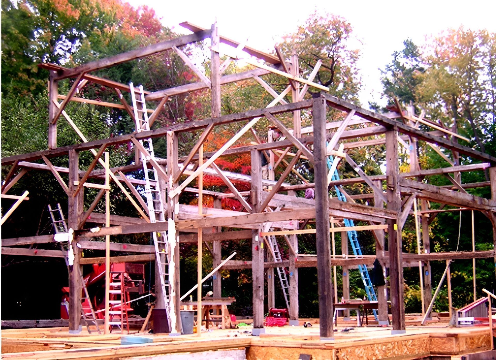 A large wooden structure is being built in the woods