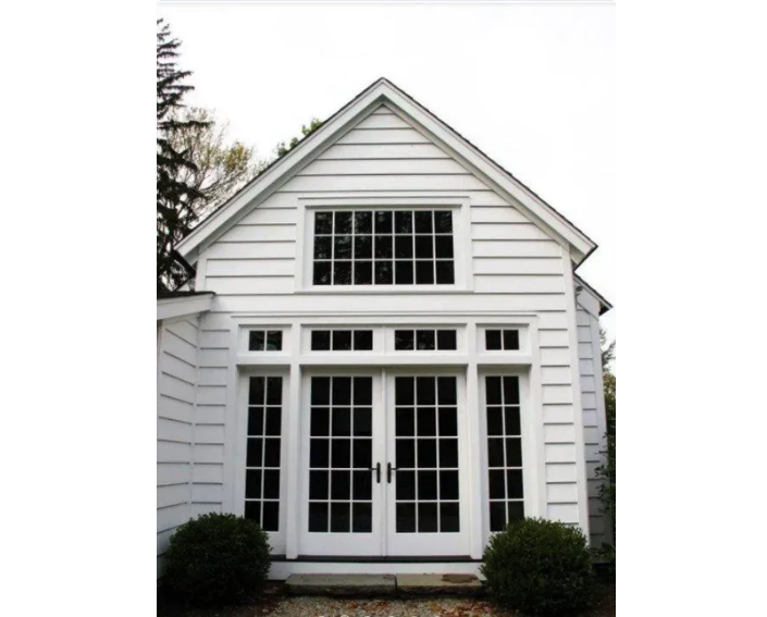 A white house with black windows and a roof