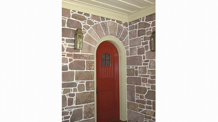 A picture of a red door in a stone wall.