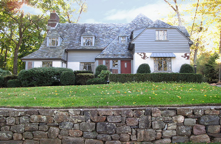 A large house with a stone wall in front of it