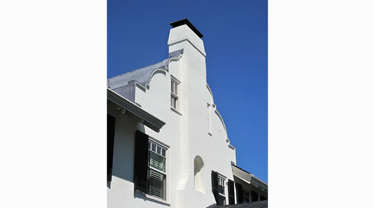 A white building with a chimney on top of it