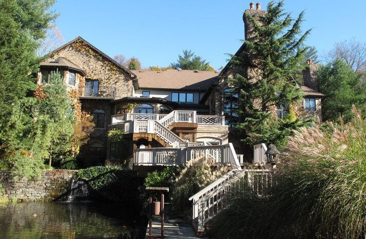 A large house with a bridge over a body of water