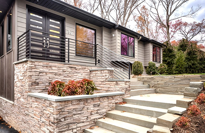 A house with stairs leading up to it and a balcony.