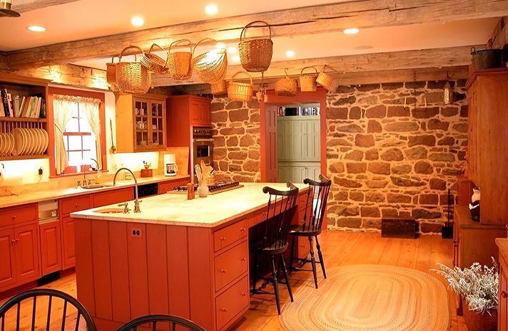 A kitchen with a large island and a stone wall