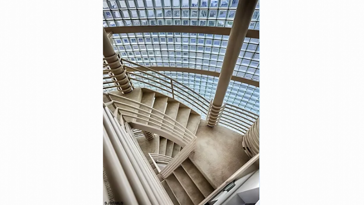 A spiral staircase with a glass ceiling in a building.