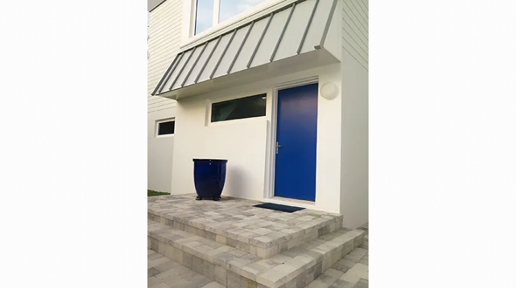 A blue door is on the side of a white building.