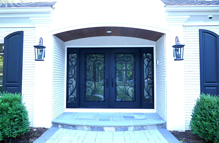 A white house with a black door and blue shutters