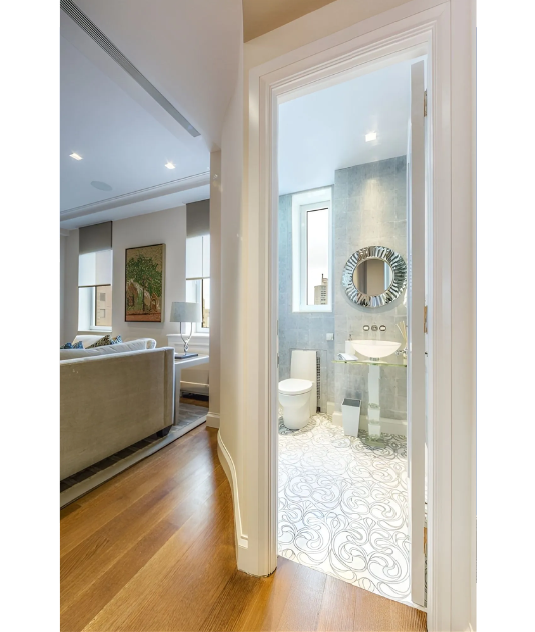 A hallway leading to a bathroom with a toilet and sink