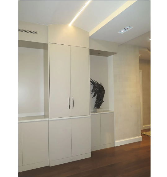 A hallway with white cabinets and a statue on the wall