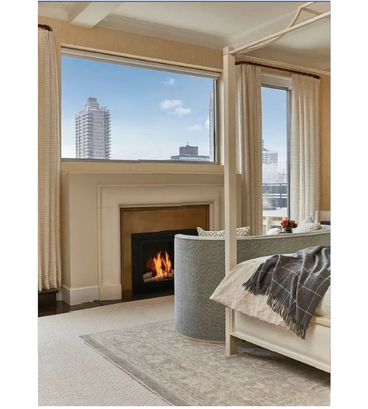 A bedroom with a canopy bed and a fireplace